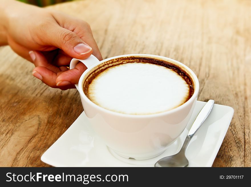 Female hand holding a white cup coffee. Female hand holding a white cup coffee