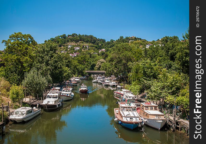 Horizontal photo of a river with many boats on it. There is a forest and some buildings in the background. This is Goksu River from Turkey / Istanbul, Rumeli. Horizontal photo of a river with many boats on it. There is a forest and some buildings in the background. This is Goksu River from Turkey / Istanbul, Rumeli.