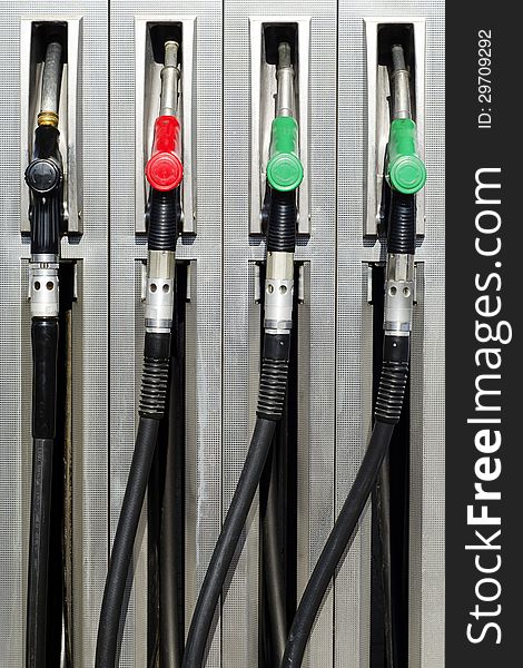 Four refuel nozzles at a petrol or gas station.