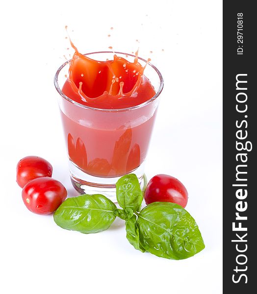 Fresh tomato juice splashing with basil
