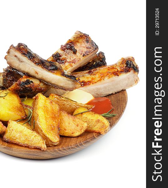 Barbecue Pork Ribs and Roasted Potato Wedges with Ketchup and Cheese Sauce closeup on Wooden Plate