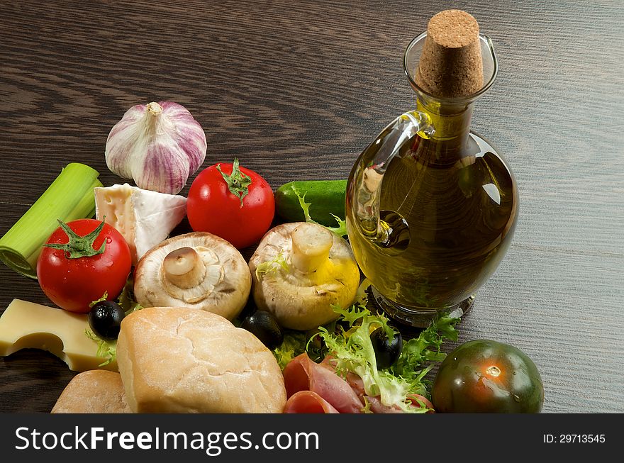 Provence Still Life with Vegetables, Hamon, Ciabatta, Cheese and Olive Oil closeup on Dark Wood background