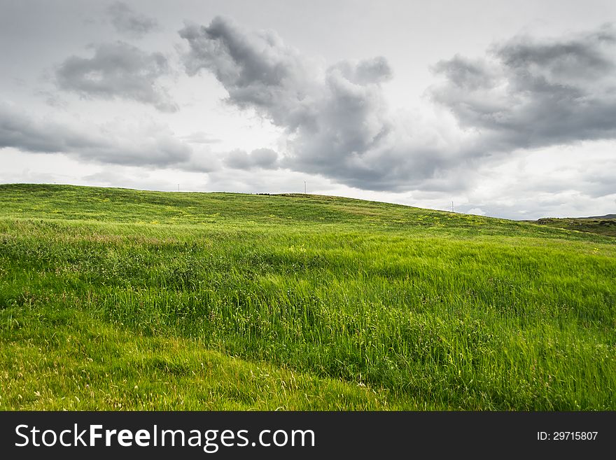 Green grass and dramatic cloudy sky background with country view