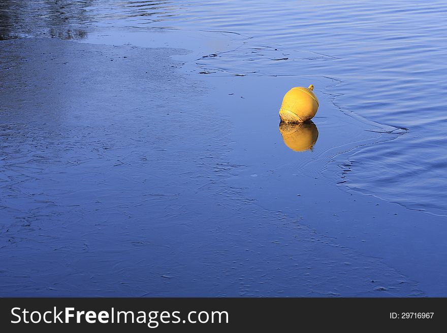 Yellow buoy on blue ice