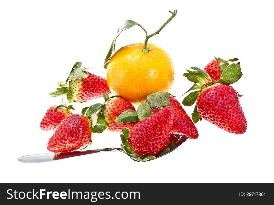 Orange with strawberries and spoon isolated on white.