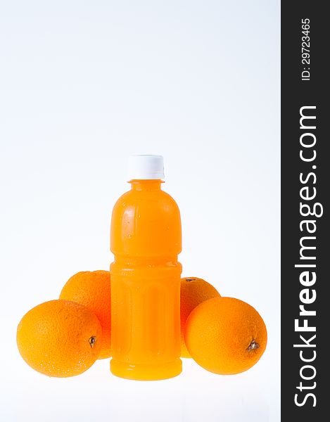 Orange juice in a bottle and orange next to it isolated on background