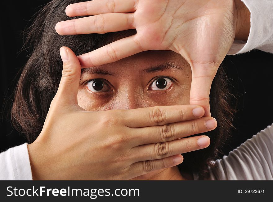 A woman framing her eyes with her hand. A woman framing her eyes with her hand