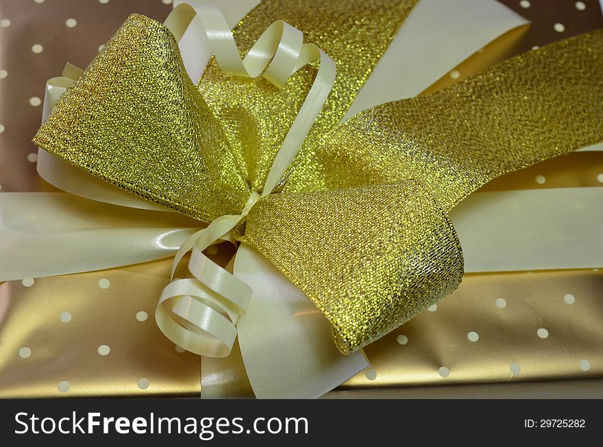 Close up shot of yellow, golden and white ribbons on wrapped gift. Close up shot of yellow, golden and white ribbons on wrapped gift