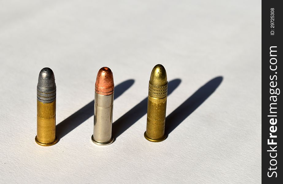 Various types of .22 ammunition on white background in strong light. Various types of .22 ammunition on white background in strong light
