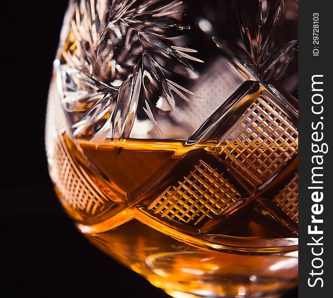 Shot of a cut crystal glass containing brandy.