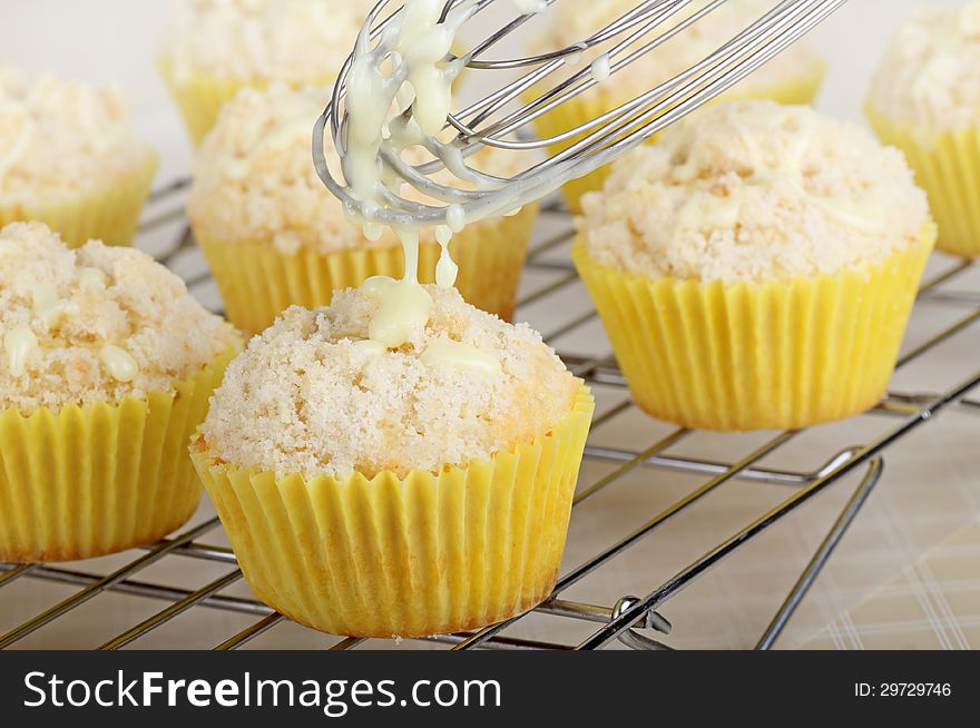 Drizzleing icing on top of lemon cupcakes. Drizzleing icing on top of lemon cupcakes