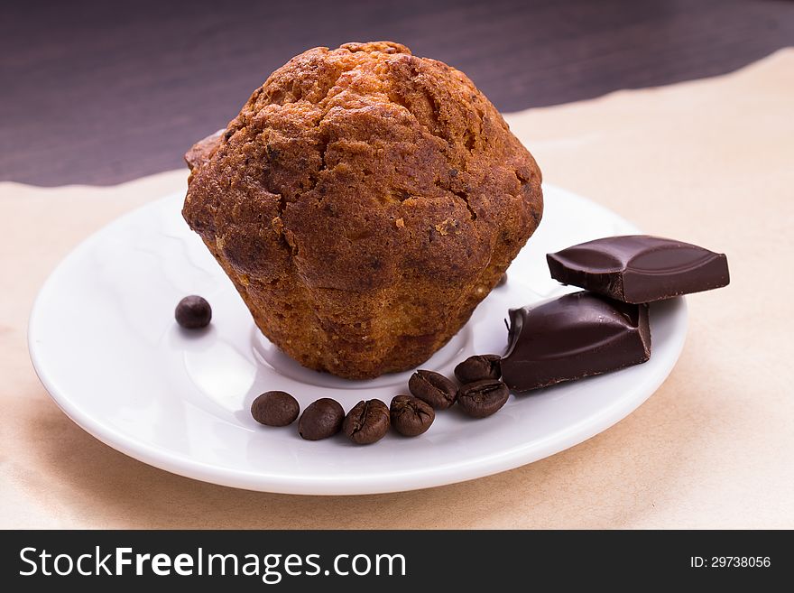 Cake with chokolate and coffee beans on white saucer