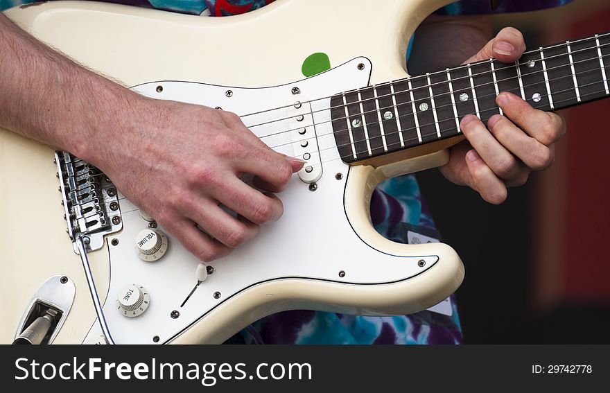 Closeup of a electric guitar and musician picks out some slick riffs. Closeup of a electric guitar and musician picks out some slick riffs
