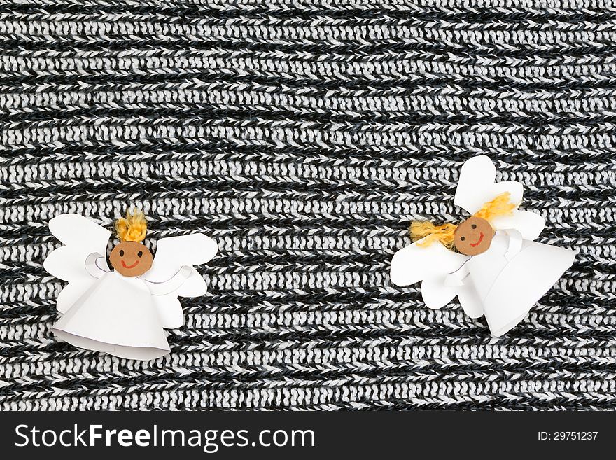 Two cheerful paper angel on monochrome background