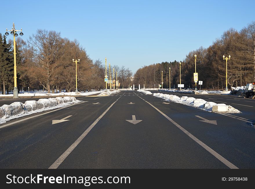 Empty road marked with three wite arrows that prescribe to move straight. Empty road marked with three wite arrows that prescribe to move straight