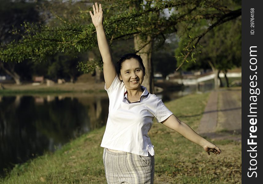 Woman Doing Morning Exercises In The Park