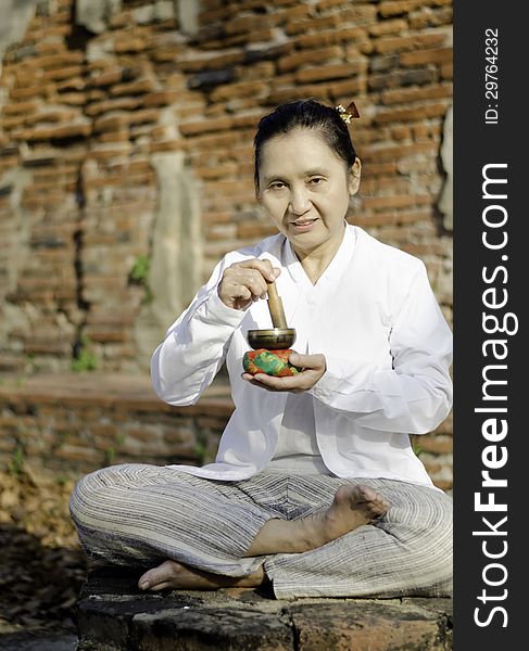Woman playing a tibetan bowl, traditionally used to aid meditation in Buddhist cultures.