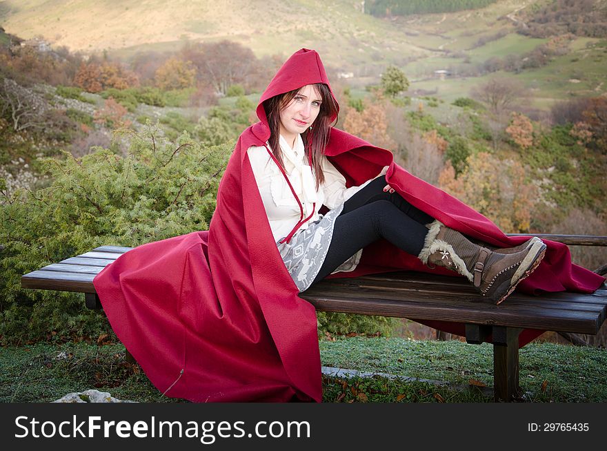 Young woman with red hood in the mountain