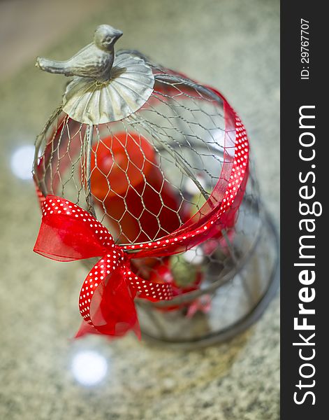 Steel cage ornament with red ribbon