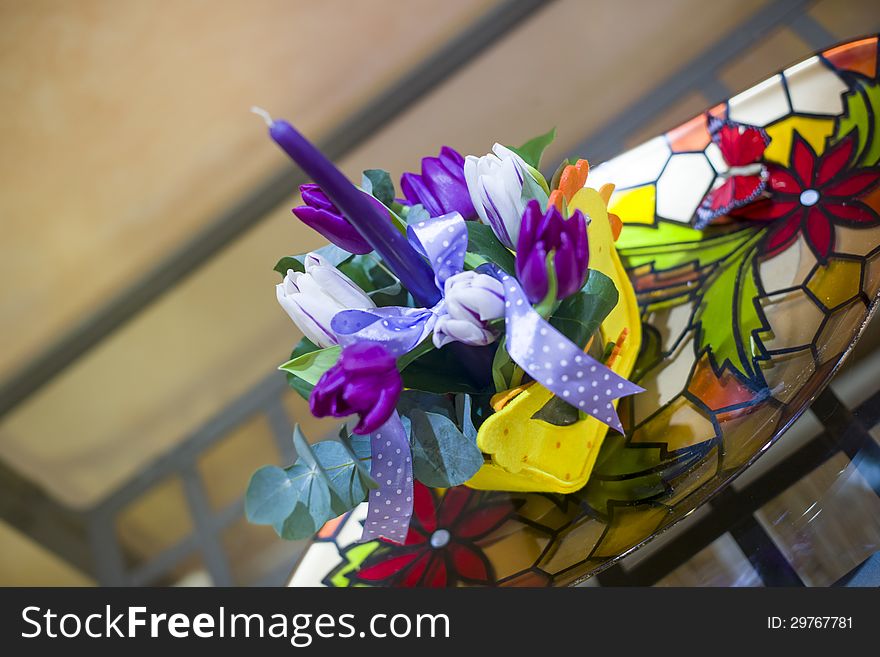 Table piece for Easter with purple candle and beautiful tulips. Table piece for Easter with purple candle and beautiful tulips