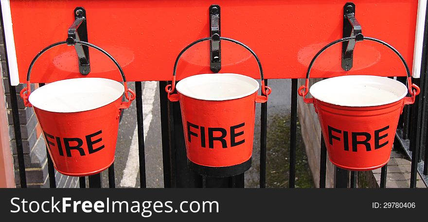 Three Traditional Fire Buckets Hanging in a Row. Three Traditional Fire Buckets Hanging in a Row.