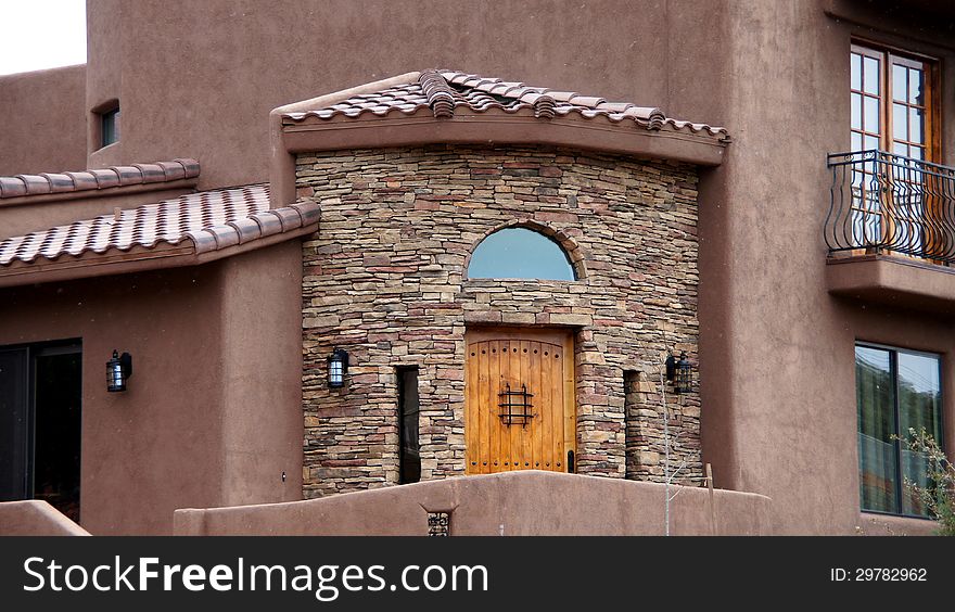 Stucco and brick stone home entrance with wooden door. Stucco and brick stone home entrance with wooden door.