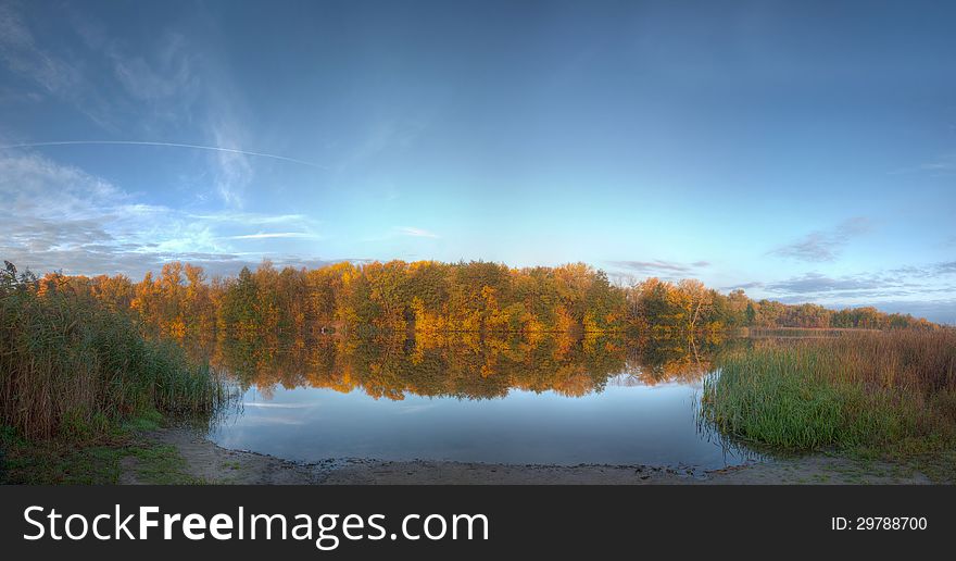 Autumn lake quiet, calm water, reeds, colorful forest. Autumn lake quiet, calm water, reeds, colorful forest