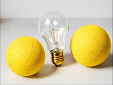 An Electric Light Bulb And Two Yellow Balls. Stock Photo An Electric Light Bulb And Two Yellow Balls. Stock Photo
