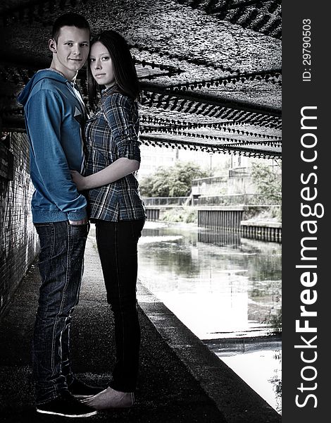 Young women and men together looking straight to the camera, full length standing under the bridge. Young women and men together looking straight to the camera, full length standing under the bridge.