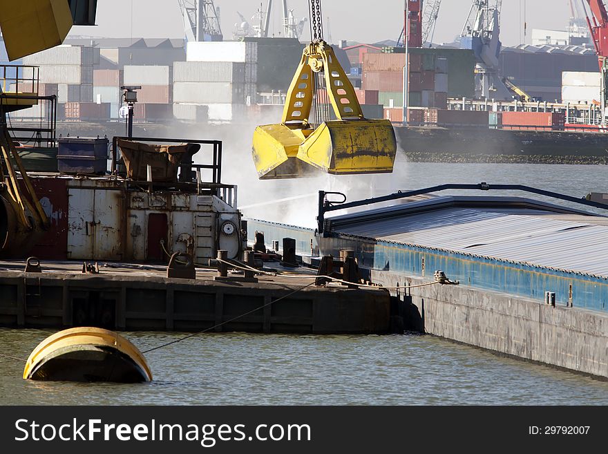 Big grab loading bulk in a barge in the Port of Rotterdam