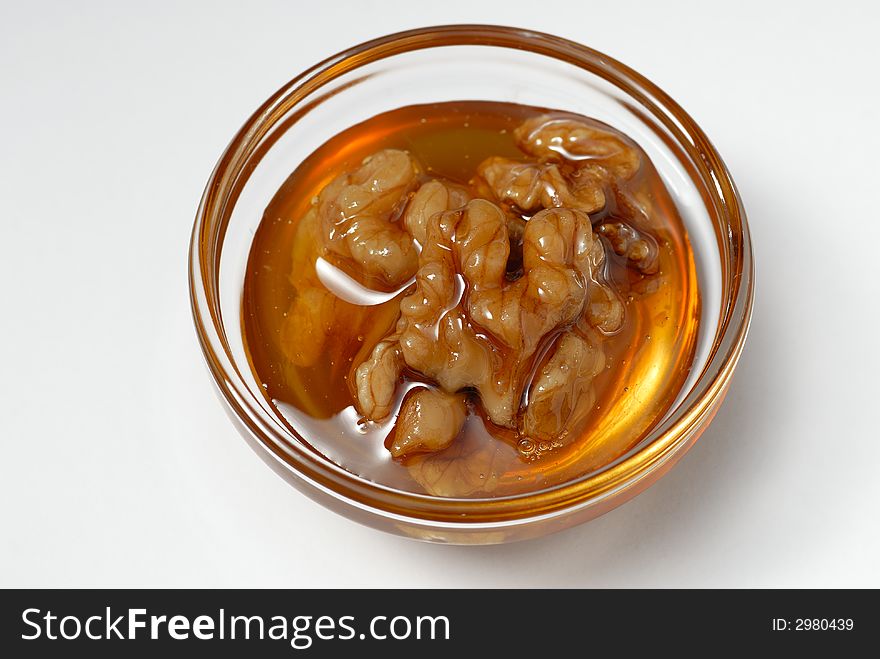 Macro of peeled walnut core in bee honey - power for the brain. Macro of peeled walnut core in bee honey - power for the brain