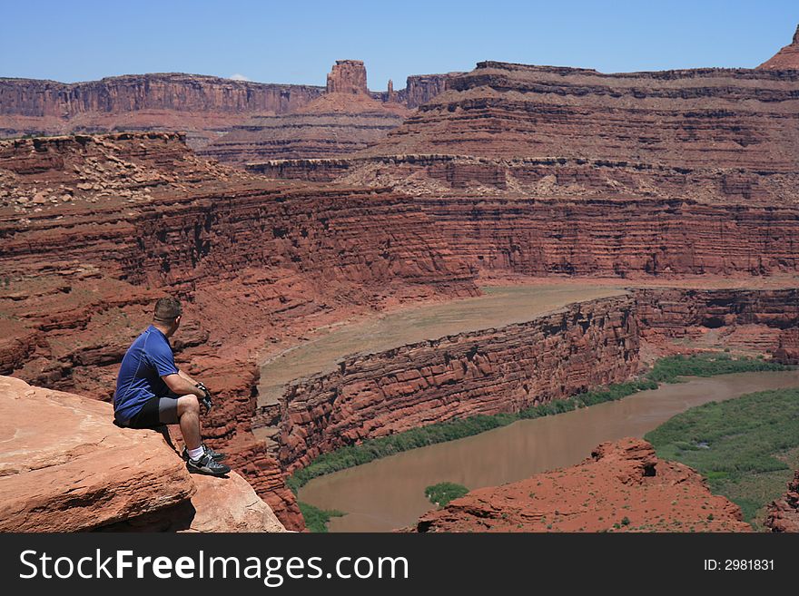 Mountain biker Canyonlands Nat’l Park overlooking Colorado River taking a breather. Mountain biker Canyonlands Nat’l Park overlooking Colorado River taking a breather