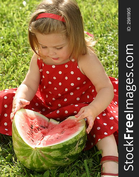 Little girl in red dress eating watermelon. Little girl in red dress eating watermelon