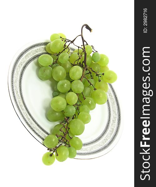 Grape cluster on a plate isolated on white background. Grape cluster on a plate isolated on white background