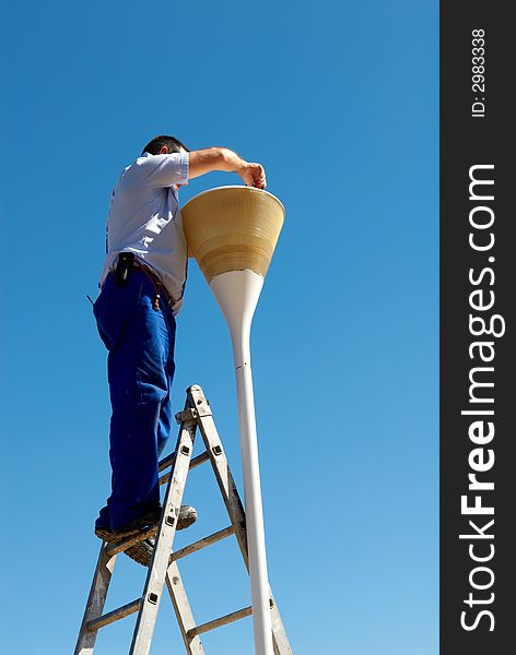 Man changing the lamp against blue