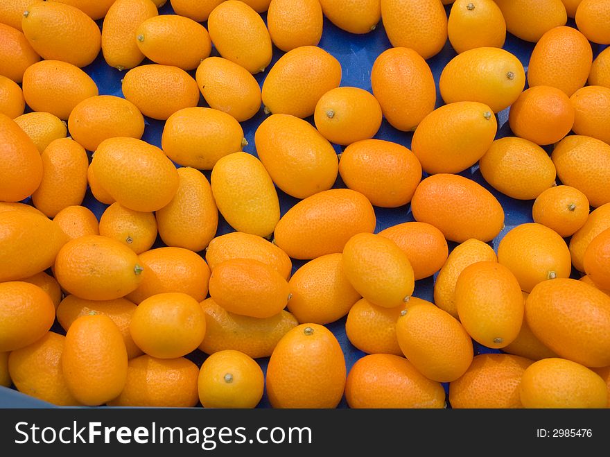 Orange Kumquats in a box with blue background