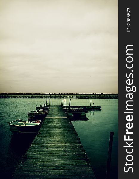 Cross-processed wooden pier with moored boats. Cross-processed wooden pier with moored boats