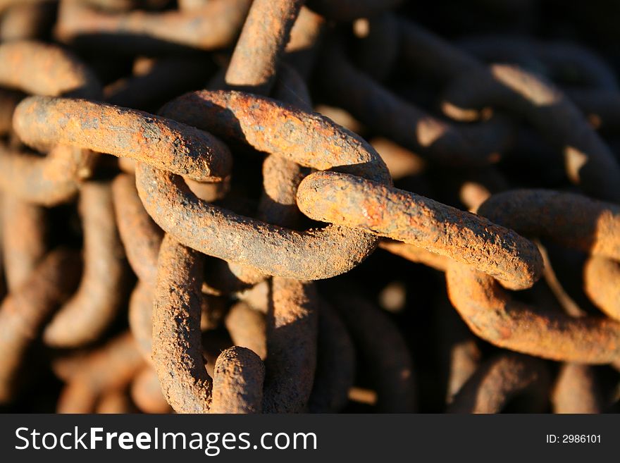 Close view of links in a rusty iron chain (background). Close view of links in a rusty iron chain (background).