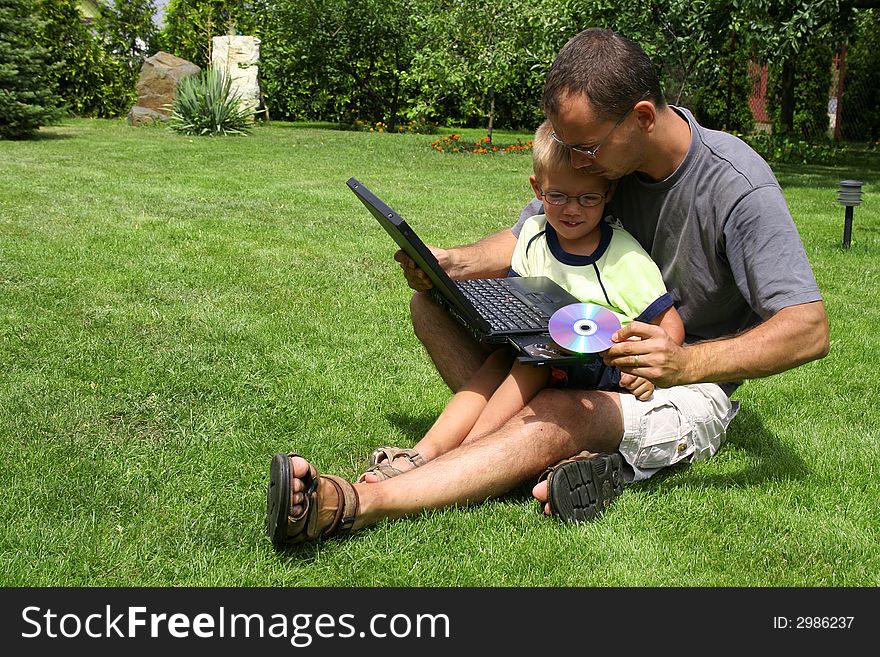Father and son with a computer outside