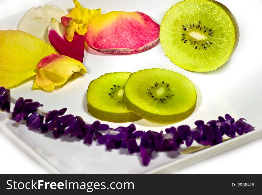 SLiced kiwi fruit on while plate, decorated with flowers