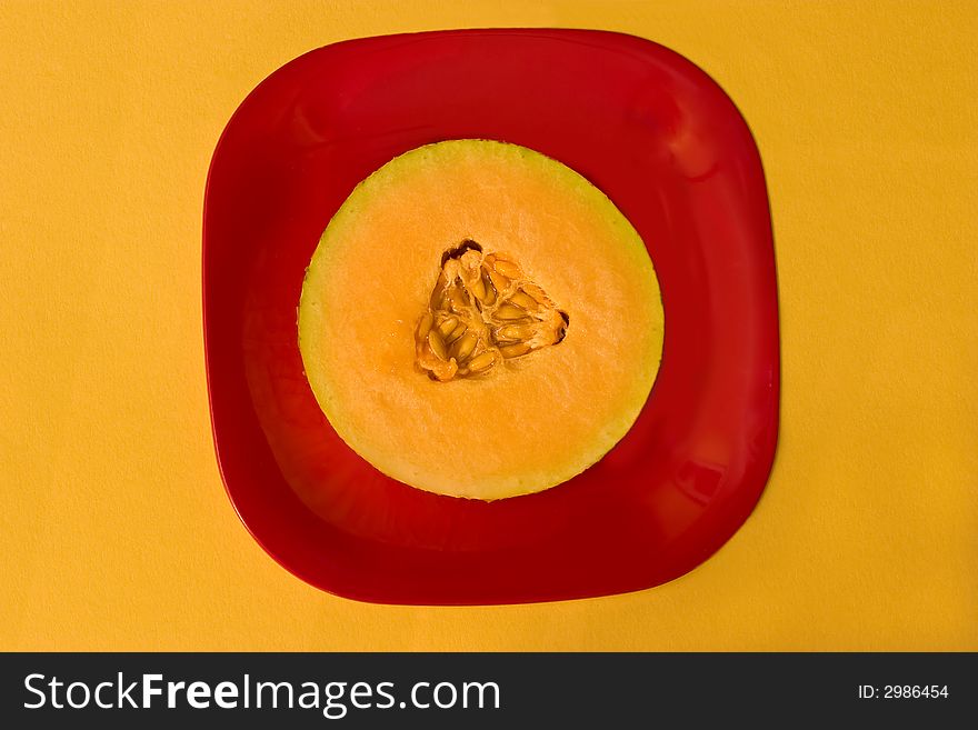 Slice of fresh melon on red plate