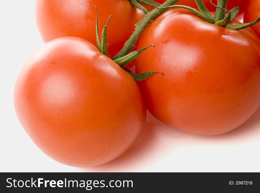 Three red juicy tomatoes on white background