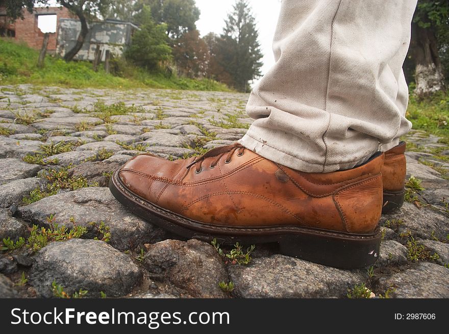 An image of boots on a road of stone. An image of boots on a road of stone