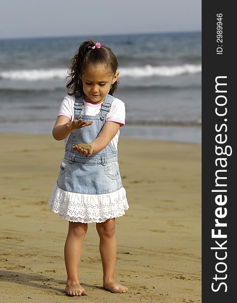 Happy child is playing with sand on the beach. Happy child is playing with sand on the beach.