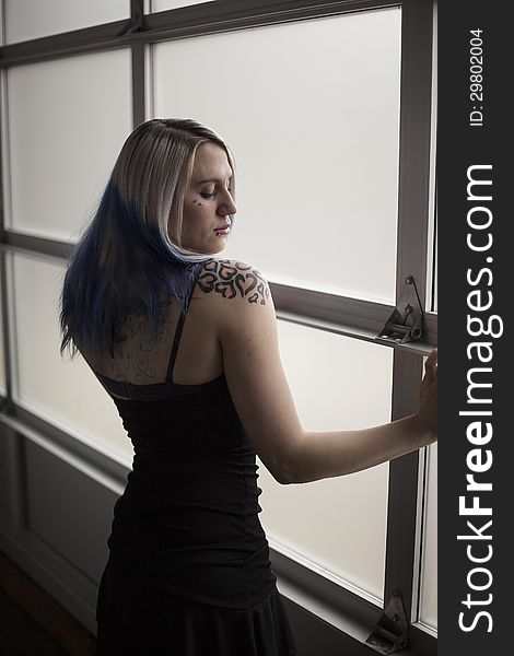 Portrait of a beautiful young woman with blue hair and a very short black dress. Portrait of a beautiful young woman with blue hair and a very short black dress.