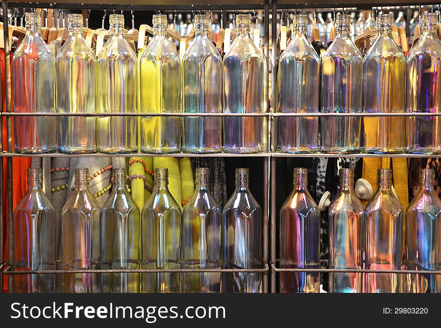 Multi-colored bottles on glass shelves