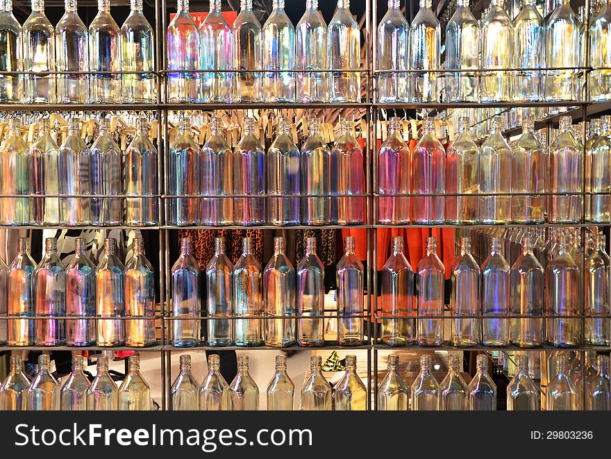 Background of many colorful glass bottles on shelves