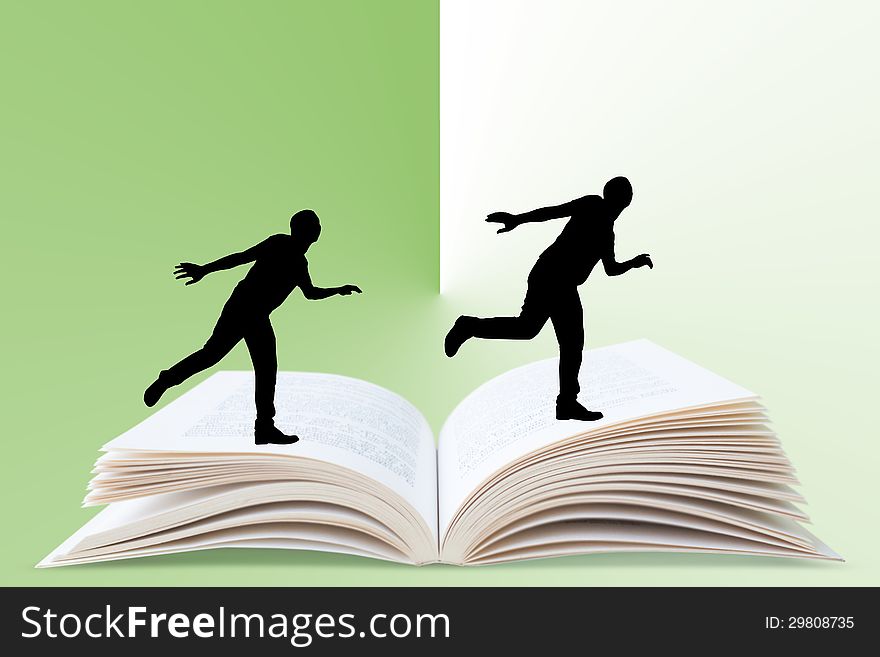 A silhouette of a man running on an open book. A silhouette of a man running on an open book.