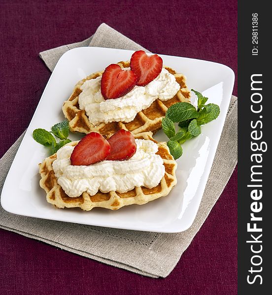 Wafer with cream and strawberries on plate