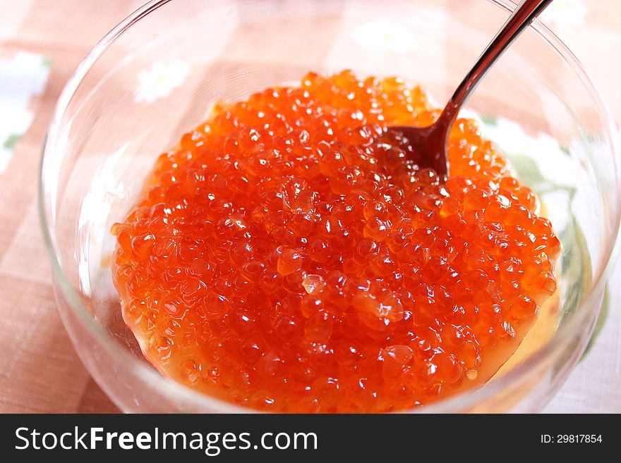 Image of red caviar in a plate with the spoon